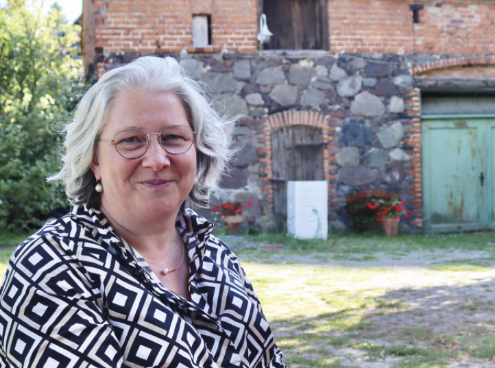 Diakonin Kristin von Campenhausen vor einer Dorfkirche